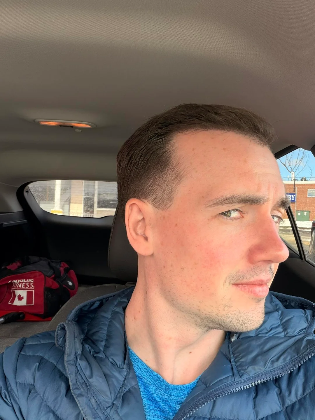 Tyler J. McInnes seated in a car, facing right