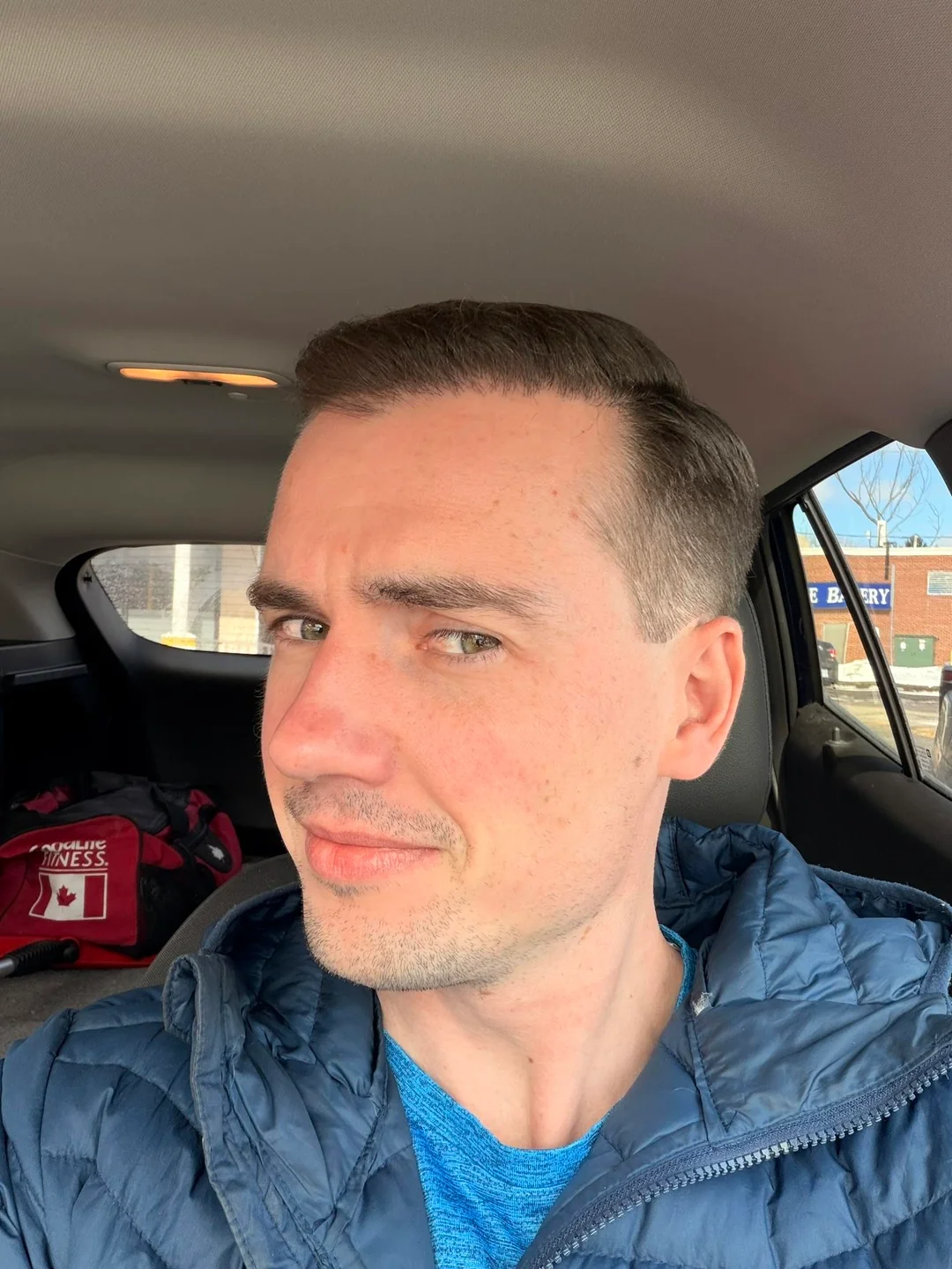 Tyler J. McInnes seated in a car, facing left